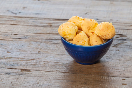 Pestic Brazilian, Cheese Bread. On a rustic table. And the bottom is a blue coffee pot.の写真素材