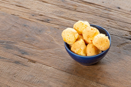 Pestic Brazilian, Cheese Bread. On a rustic table. And the bottom is a blue coffee pot.の写真素材