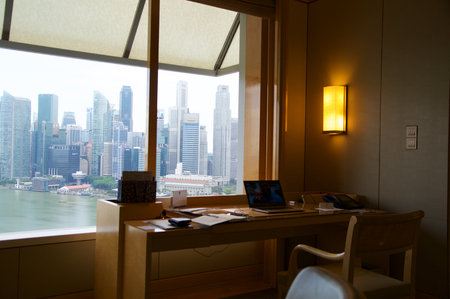 SINGAPORE - JULY 23rd, 2016: luxury Hotel room with modern interior and an awesome view of the Marina Bay, working desk with laptop.のeditorial素材