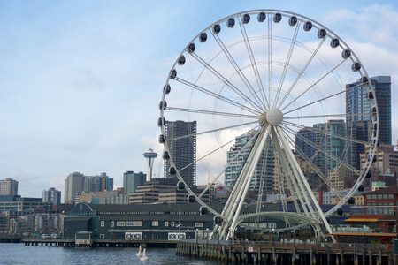 SEATTLE, WASHINGTON, USA - JAN 25th, 2017: A view on Seattle downtown from the waters of Puget Sound. Piers, skyscrapers, Space Needle and Ferris wheel in Seattle city before sunsetのeditorial素材