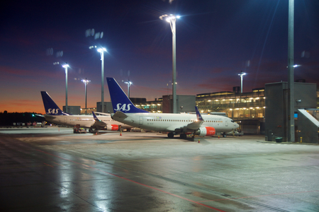 OSLO, NORWAY - JAN 21st, 2017: The Oslo Lufthavn Airport Gardermoen OSL is the main airport in Norway and a hub for the low cost airline Norwegian Air Shuttle DY and SAS Scandinavian Airlines SK . Boeing 737 at the Gate druing the early morningのeditorial素材