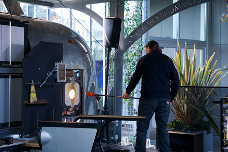 SEATTLE, WASHINGTON, USA - JAN 23rd, 2017: A man takes motlen glass and shapes it using some specialized tools for glassblowing art at an exhibit by American artist Dale Chihuly at Chihuly Garden and Glass Museumのeditorial素材