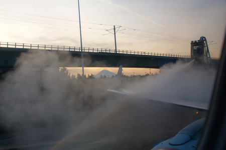 SEATTLE, WASHINGTON, USA - JAN 27th, 2017: Process of aircraft wings de-icing with antifreeze before takeoff during strong blizzard. Deicing is important during winter or in the morning, view from inside the airplane at SeaTacのeditorial素材