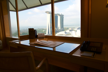 SINGAPORE - JULY 23rd, 2016: luxury Hotel room with modern interior and an awesome view of the Marina Bay, working desk laptopのeditorial素材