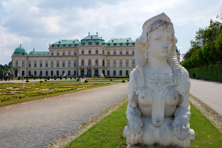 VIENNA, AUSTRIA - APR 30th, 2017: Upper Belvedere Palace with a close-up of a statue of a horse at the entrance on a sunny day with blue sky and clouds in summer and tourists walkingのeditorial素材