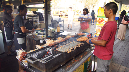 SINGAPORE - APR 3rd, 2015: Delicious tasty skewers of chicken cook over hot coals in Singapores Satay Street food marketのeditorial素材