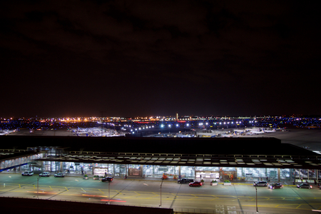 CHICAGO, ILLINOIS, UNITED STATES - MAY 11th, 2018: Outside of Chicago OHare International Airport at night with some cars and airplanes at the terminalのeditorial素材