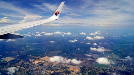 KUALA LUMPUR, MALAYSIA - APR 11th, 2015: Wing view during flight with a airplane with blue skys and...