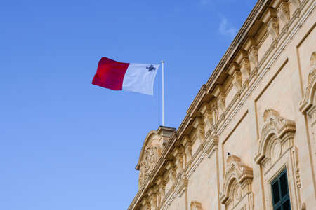 VALLETTA, MALTA - DEC 31st, 2019: Roof of the Auberge de Castille (now office of the Prime Minister of Malta) topped with a Maltese flag with the coats of arms of Castile and Leon and Portugalのeditorial素材