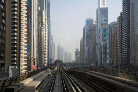 DUBAI, UNITED ARAB EMIRATES - JUN 19, 2019: Dubai Financial center along Sheikh Zayed road and metro railway in luxury skyscraper city with futuristic buildingsのeditorial素材