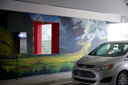 DETROIT, MICHIGAN, UNITED STATES - 22 MAY 2018: Silver car parked in a public car park with graffiti on the wallのeditorial素材