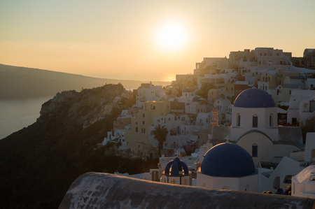 Whitewashed Houses and Church on Cliffs with Sea View and Sunset in Oia, Santorini, Cyclades, Greeceの写真素材