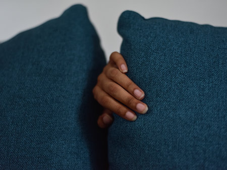 Female hand with blue couch cushionsの写真素材