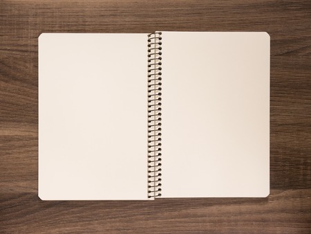 Big empty opened notepad on a wooden brown table desk.の写真素材