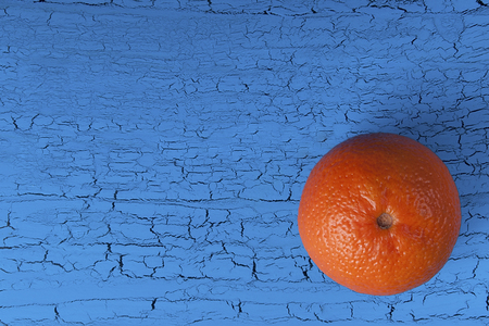 Orange mandarin on a blue background with craquelures. View from above. Close-up, copy spaceの写真素材