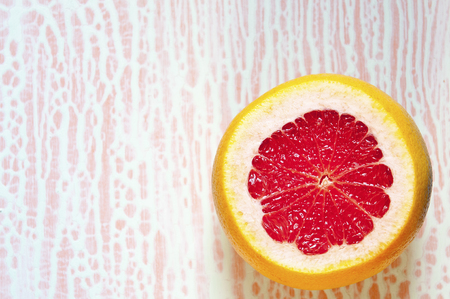 Sliced grapefruit  on an abstract white and pink background  . View from above. Close-up, copy space