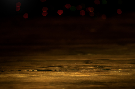 Dark abstract background with old wooden boards in the foreground and red bokeh lights. Copy Space.の写真素材