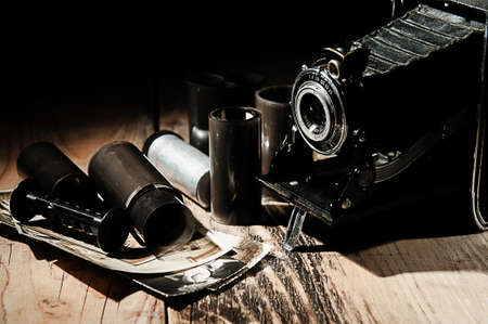 Vintage camera, photographic film and old photos on a wooden table.の写真素材