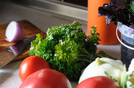Still life of fresh vegetables and herbs on the kitchen tableの写真素材