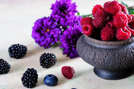 still life ripe summer berries in a black vaseの写真素材