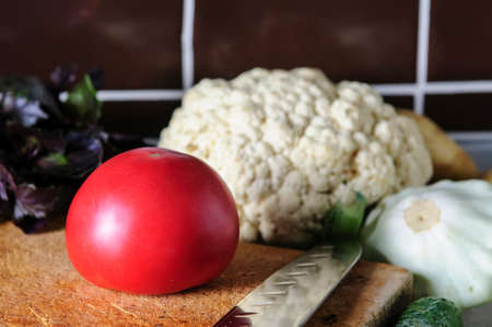 Still life of fresh vegetables and herbs on the kitchen table.