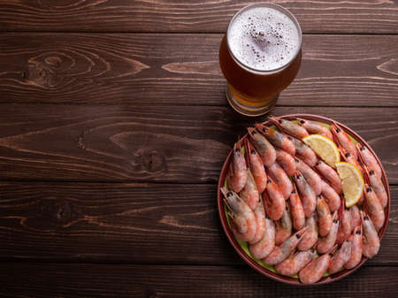 Shrimp and beer on a wooden background. The view from the top. Free space.の写真素材