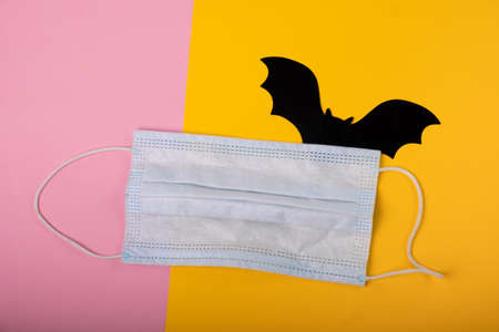 Bat and medical mask on a bright background. View from above. Covid-19の写真素材