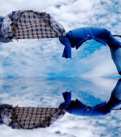 Drying shirts using wind with clouds and water in backgroundの写真素材