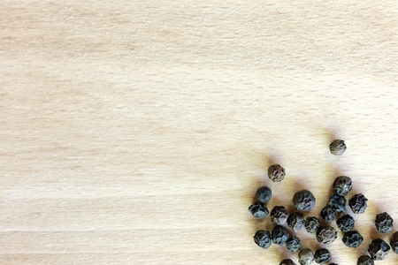 Black Pepper grains in the bottom right corner of the chopping boardの写真素材