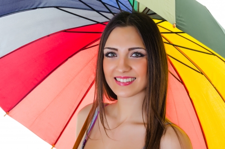 Close up portrait of beautiful brunette female with rainbow umbrella over white background の写真素材