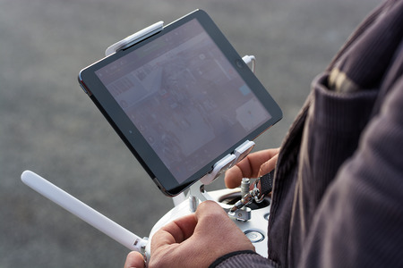 Zrenjanin, SERBIA: October 29, 2015, detail of man flying Dji Inspire 1 remote controller with Ipad displaying camera frame on AVIV park openingのeditorial素材