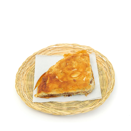Burek or pie with meat on a paper serviette in a wicker or bread basket over white backgroundの写真素材