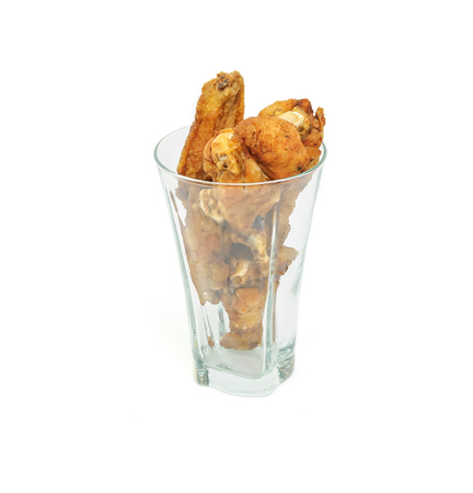 fried chicken drumsticks and wings in a glass isolated over white backgroundの写真素材