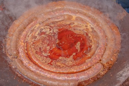 frying sausages in huge pan with grease, shallow focusの写真素材
