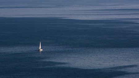 A small sailing ship on the open calm seaの写真素材