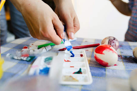 Close up on hand squeezing Paint Tubeの写真素材