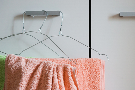 Clean towels on the hanger at the hotel room homeの写真素材