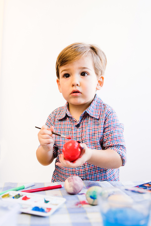 Little Boy Painting Easter Eggs At Homeの写真素材