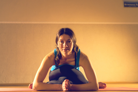 Young woman female instructor in yoga vinyasa asana ashtanga pose training at studio class stretchingの写真素材