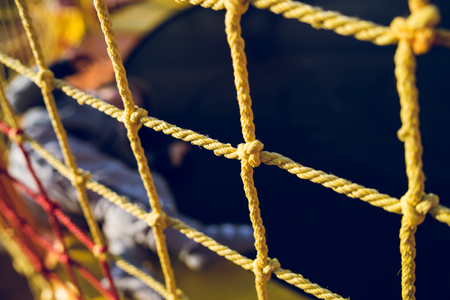Close up on the yellow safety net at the playground against dark background