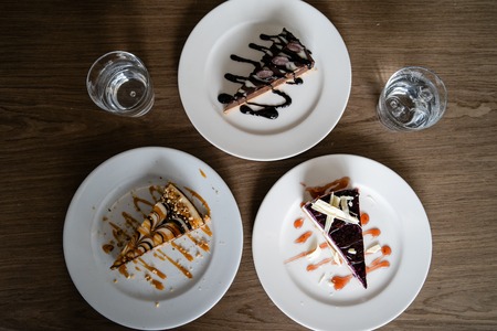 Close up on cake slices in plates on the table at the hotel restaurant