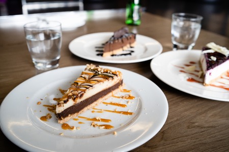 Close up on cake slices in plates on the table at the hotel restaurantの写真素材