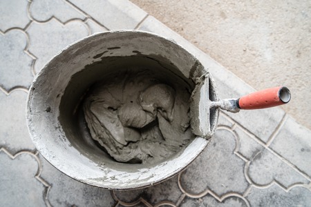High angle view on bucket with cement adhesive construction material