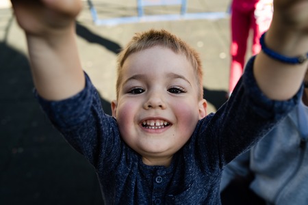 High angle view on little boy holding a bar in the park