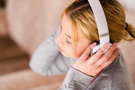Beautiful young woman listening to the music headphones enjoy at home on holiday relaxの写真素材