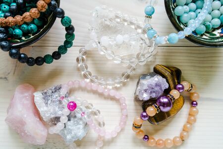 High angle view on crystal perls stones and bracelet on wooden tableの写真素材