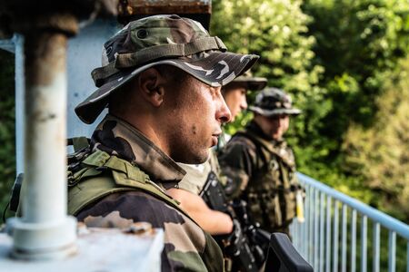 young soldiers on patrol platoon on the mission combat operation waiting for instructions on the bridge near the war zoneの写真素材