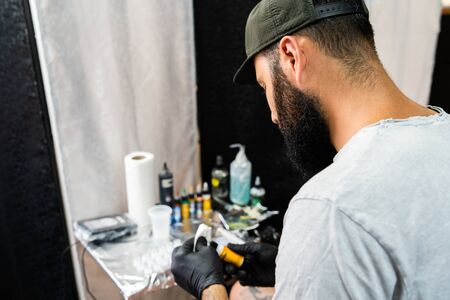 Professional tattoo artist preparing machine colors mix for artwork at studio saloon tattooingの写真素材