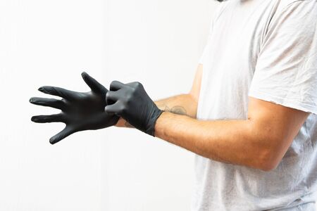 Close up on man midsection putting on black latex gloves tattoo studio