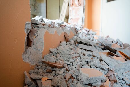 Wall smashed into debris room in apartment ready for renovation with destroyed smashed wall demolish